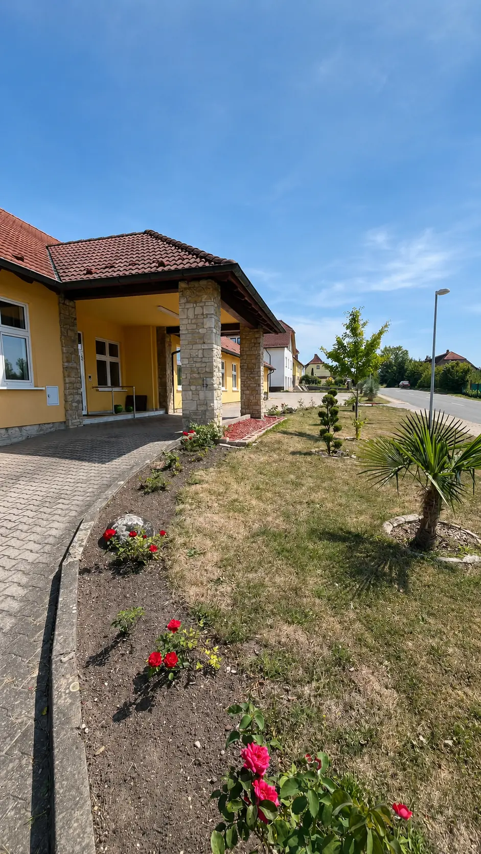 Gepflasterter Weg entlang des Praxisgebäudes zum Eingang