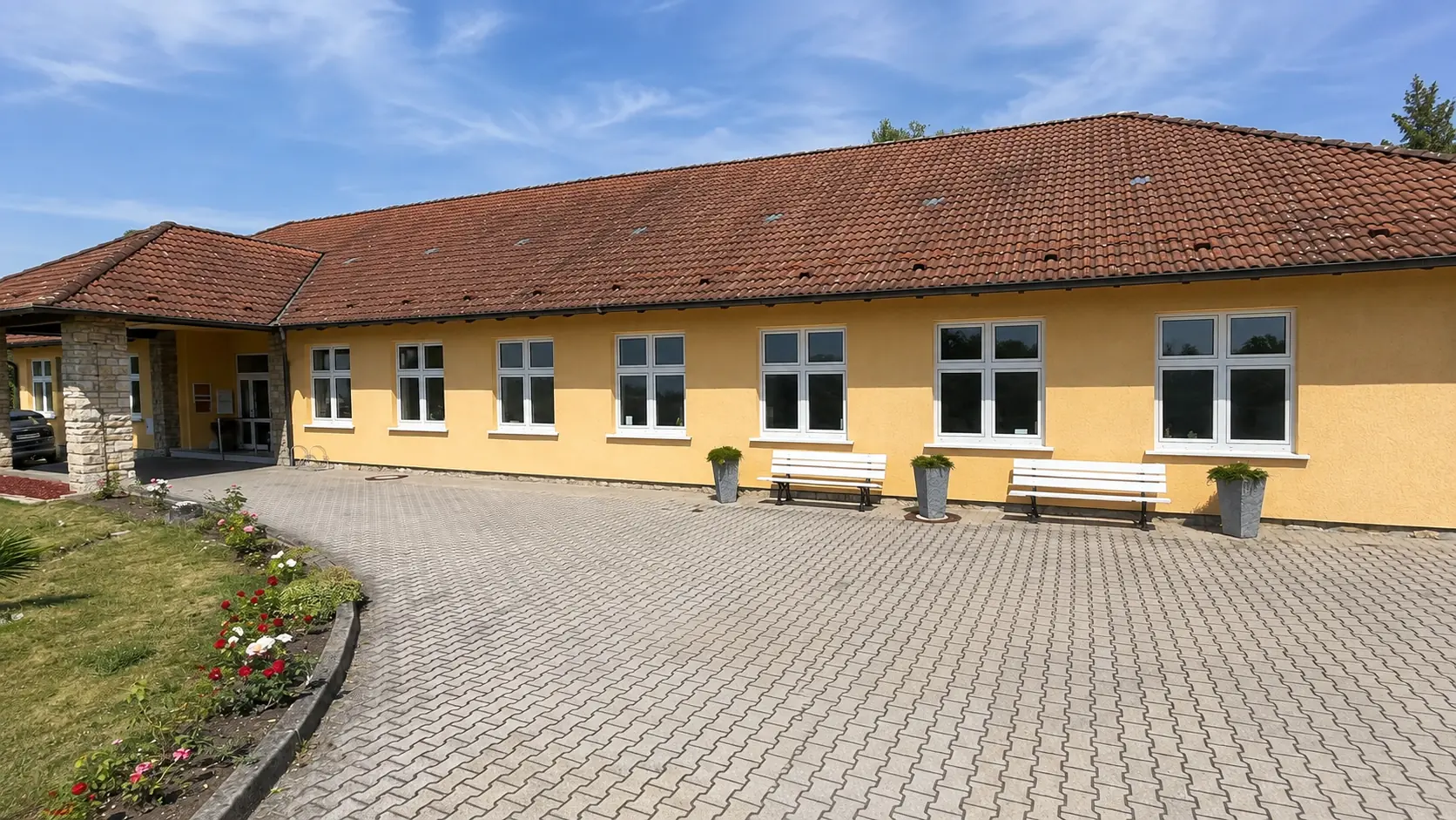 Seitliche Außenansicht des gelben Praxisgebäudes